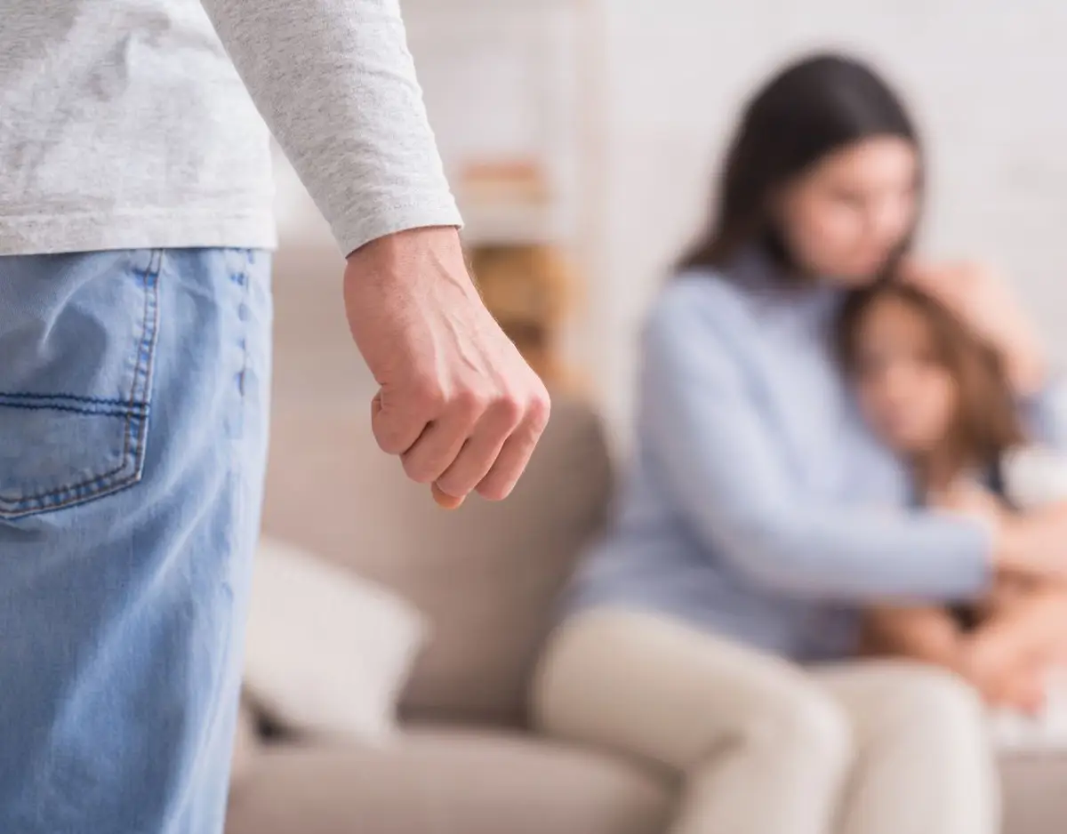 man squeezing fist in front of mom and kid