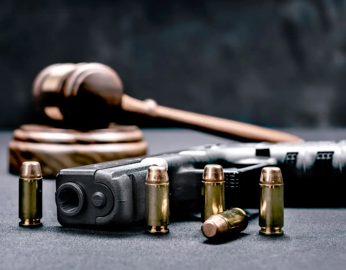 gun with bullets and gavel behind