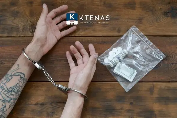 Hands handcuffed with a bag of pills a rolled up bills beside.
