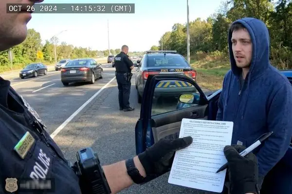 First-person body camera footage of a police officer conducting a roadside sobriety test.