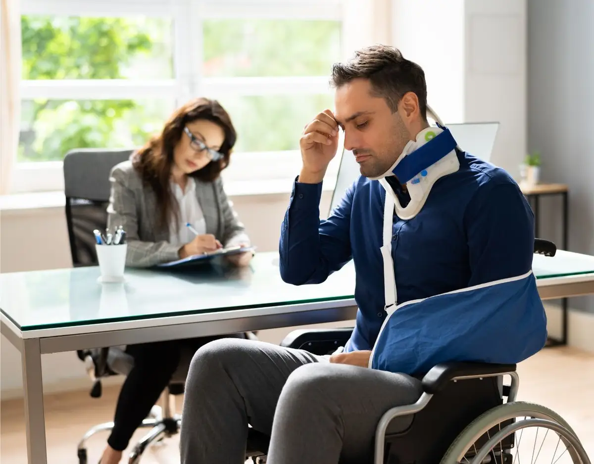 a man with an arm injury meeting with a lawyer to discuss a claim