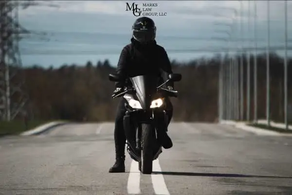 a motorcyclist stopped between two lanes on a road