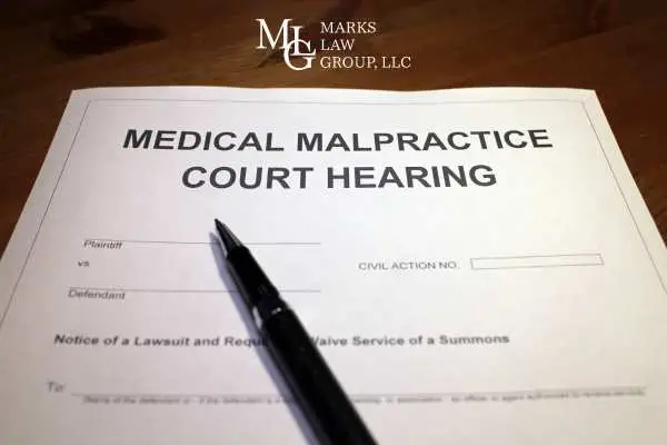 a form for a medical malpractice court hearing and pen on a desk