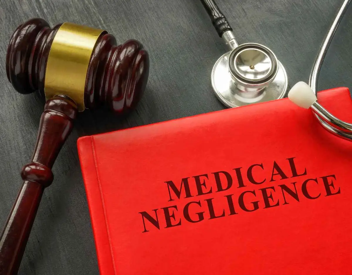 books covering medical malpractice law, a stethoscope, and gavel on a desk
