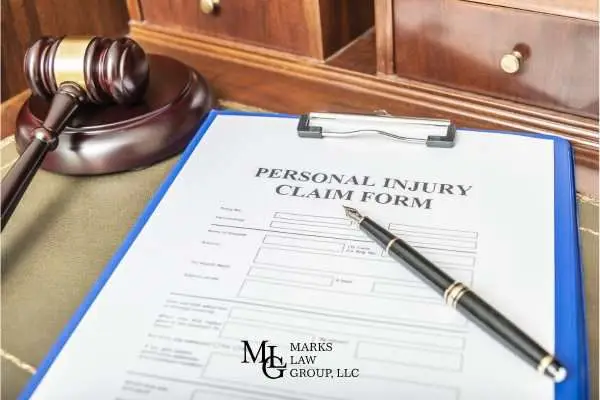 a personal injury claim form and a gavel on a lawyers desk