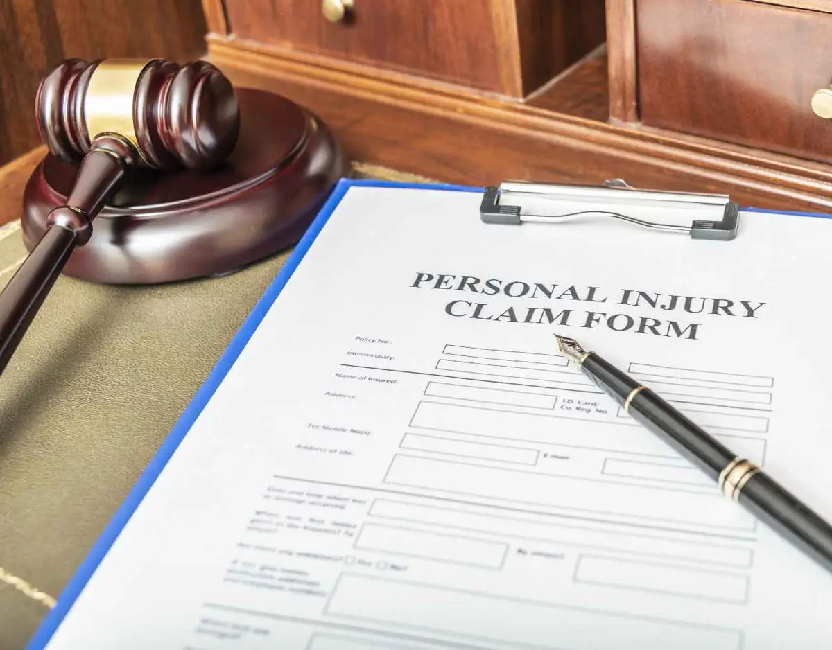 an injury claim form on a desk next to a gavel