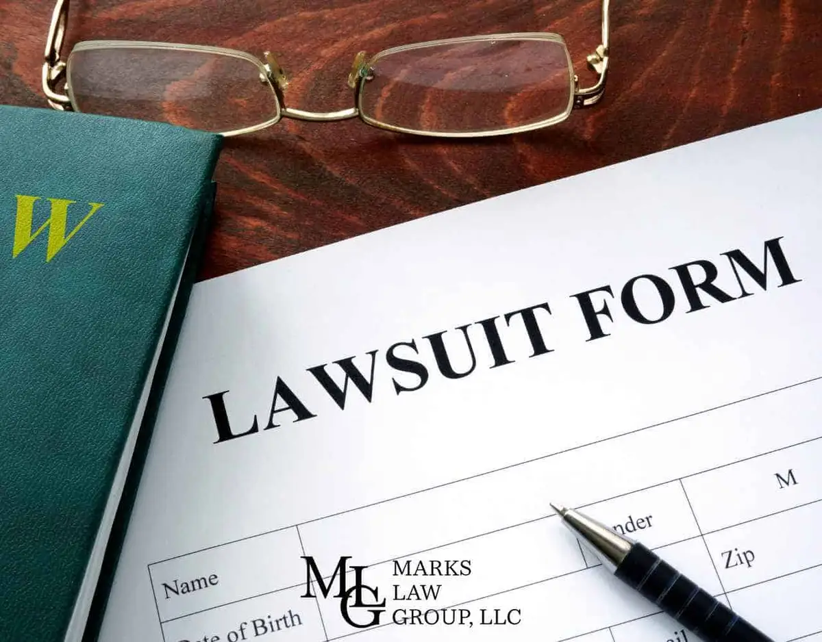 a lawsuit, legal book, pen, and glasses on a desk