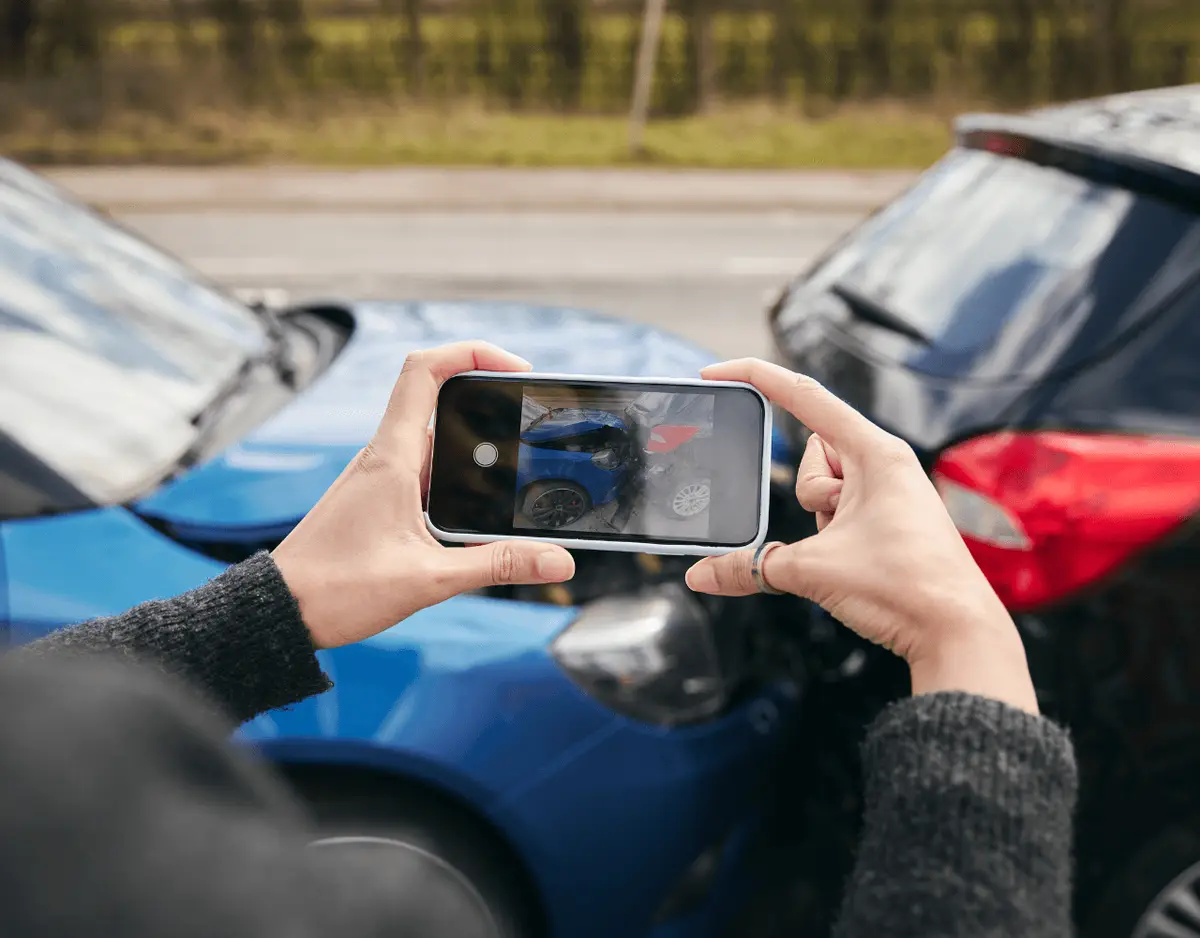 a woman taking a photograph of a car accident