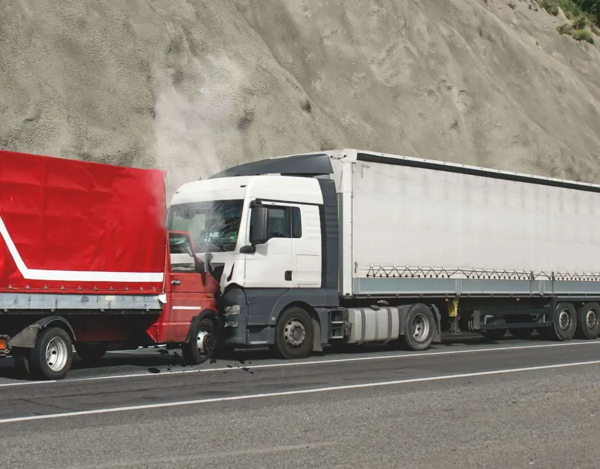 white truck hit head on by a red truck