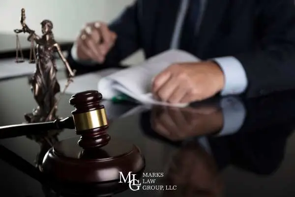 an attorney reviewing a Walmart lawsuit at a desk with a gavel and statue of justice on it