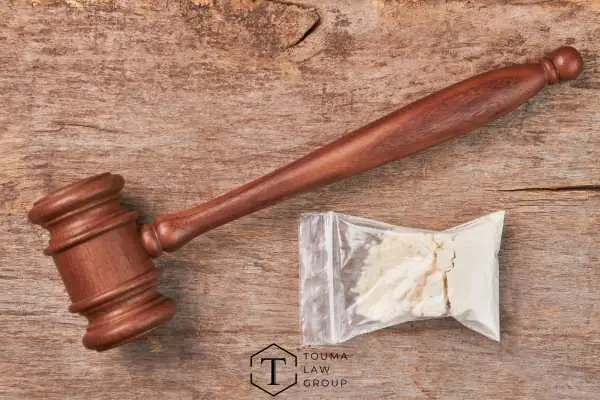 a gavel and bag of drugs on a wooden table