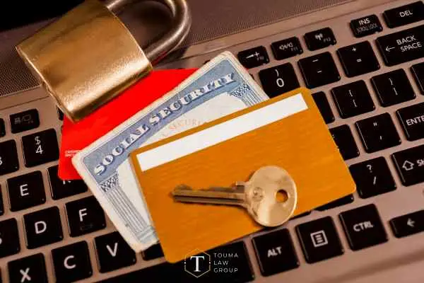 credit cards, a social security card, lock, and key on a laptop