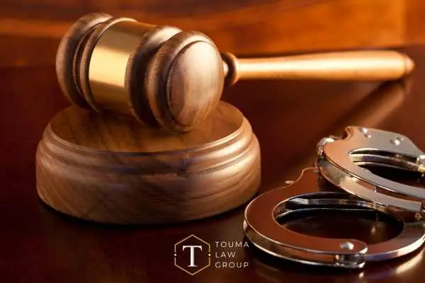 handcuffs and a gavel on a judge's desk