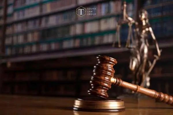 a desk in a law firm with a gavel and statue of justice on it with a bookshelf of law books in the background