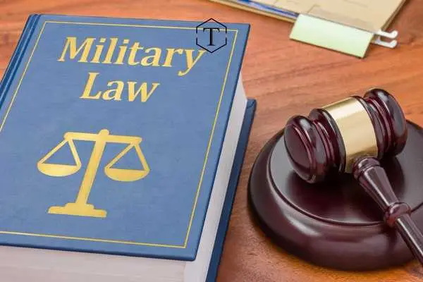 Military Law book, scale of justice, and gavel.