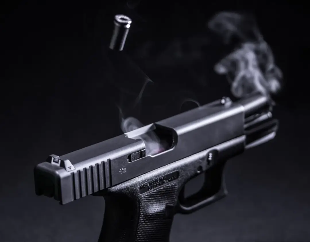smoking black gun with shell flying out the top
