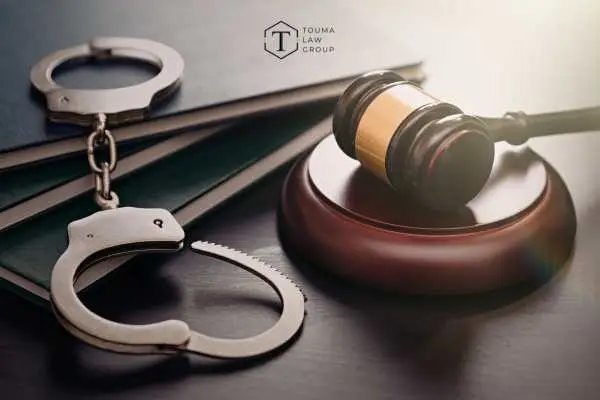 handcuffs and a gavel on a wooden desk