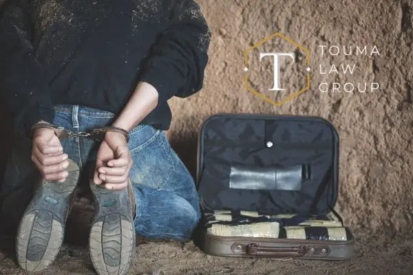 a man on his knees after being arrested for drug trafficking