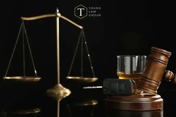 scales of justice, a gavel, and car keys in front of a black background
