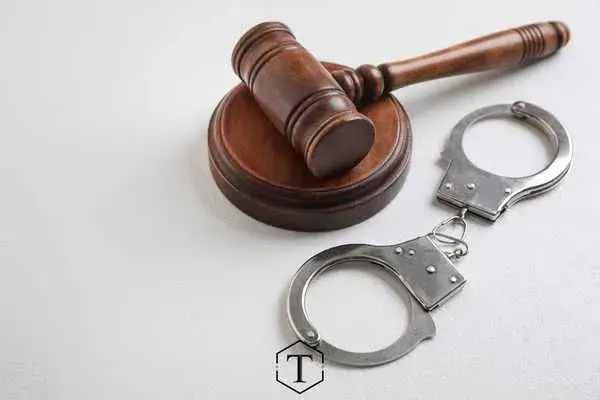 a gavel and handcuffs on a white table