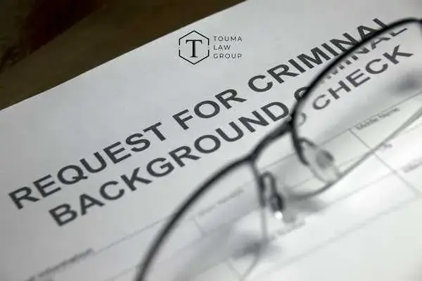 glasses and a form for a criminal background check on a desk