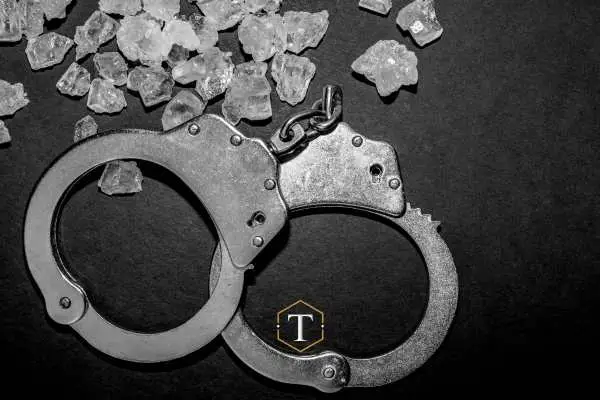 methamphetamine and handcuffs on a black desk