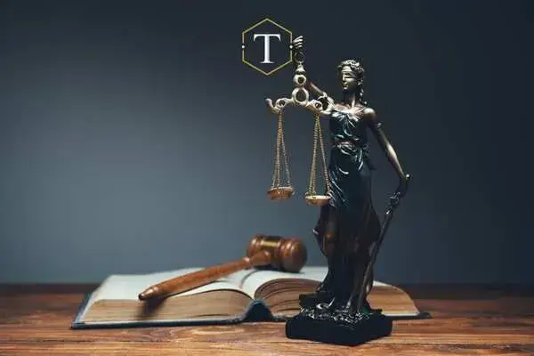 a law book, gavel, and scales of justice on a desk