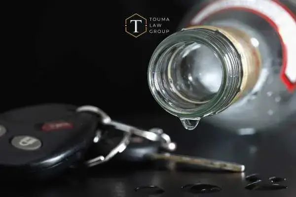 car keys and a bottle of tequila on a black table