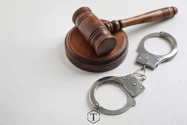 a gavel and handcuffs on a white table