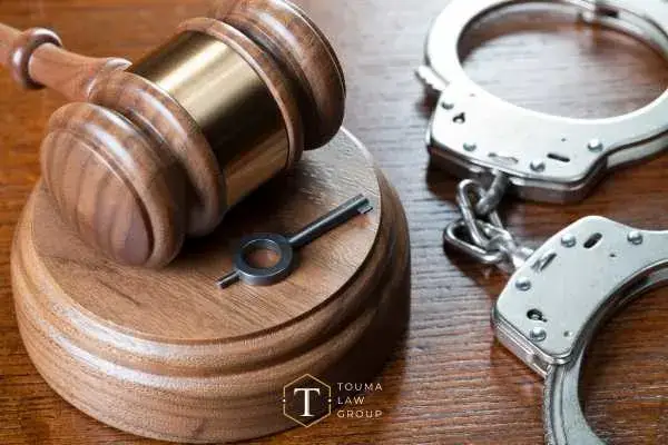 handcuffs and a gavel on a wooden desk