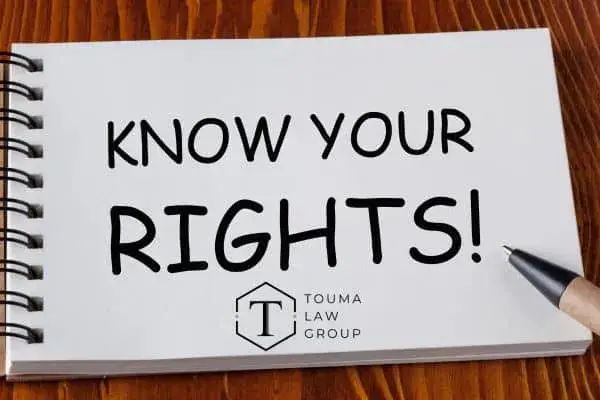 A spiral notebook on a wooden surface with the bold text "KNOW YOUR RIGHTS!"
