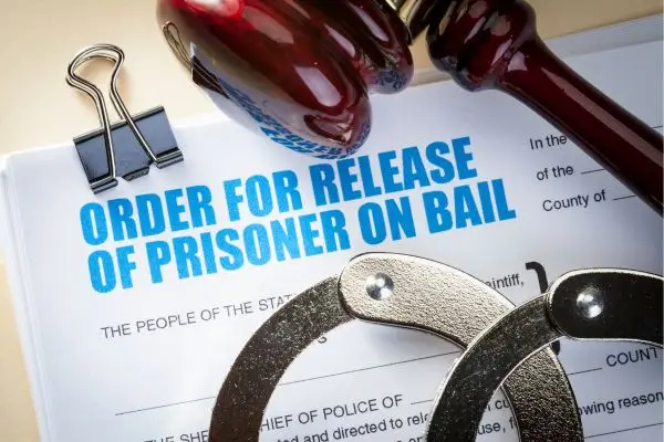 paperwork for bail bond with handcuffs and gavel on top