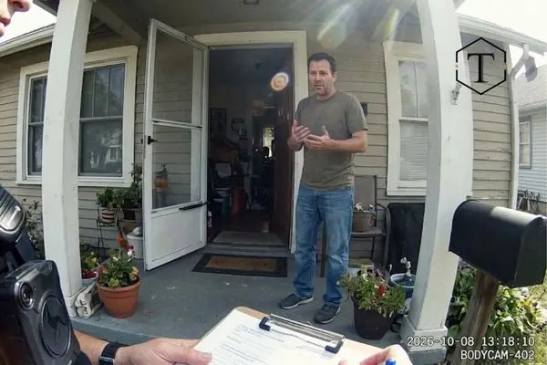 First-person bodycam perspective of a police officer speaking with a homeowner on a front porch